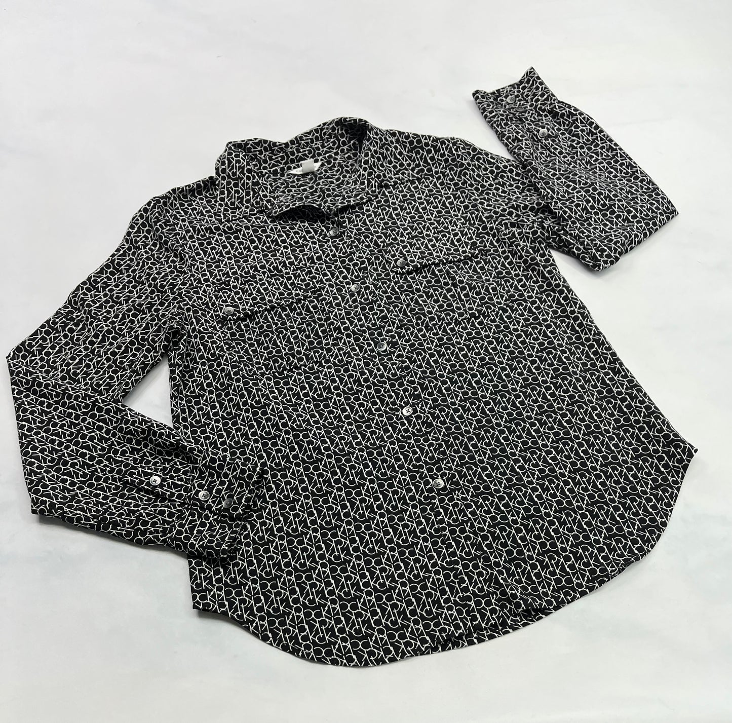 ..Calvin Klein : Chemisier tissu chic mou confo . Fait Small femme comme neuve . Inscrit Calvin Klein partout sur la chemise .