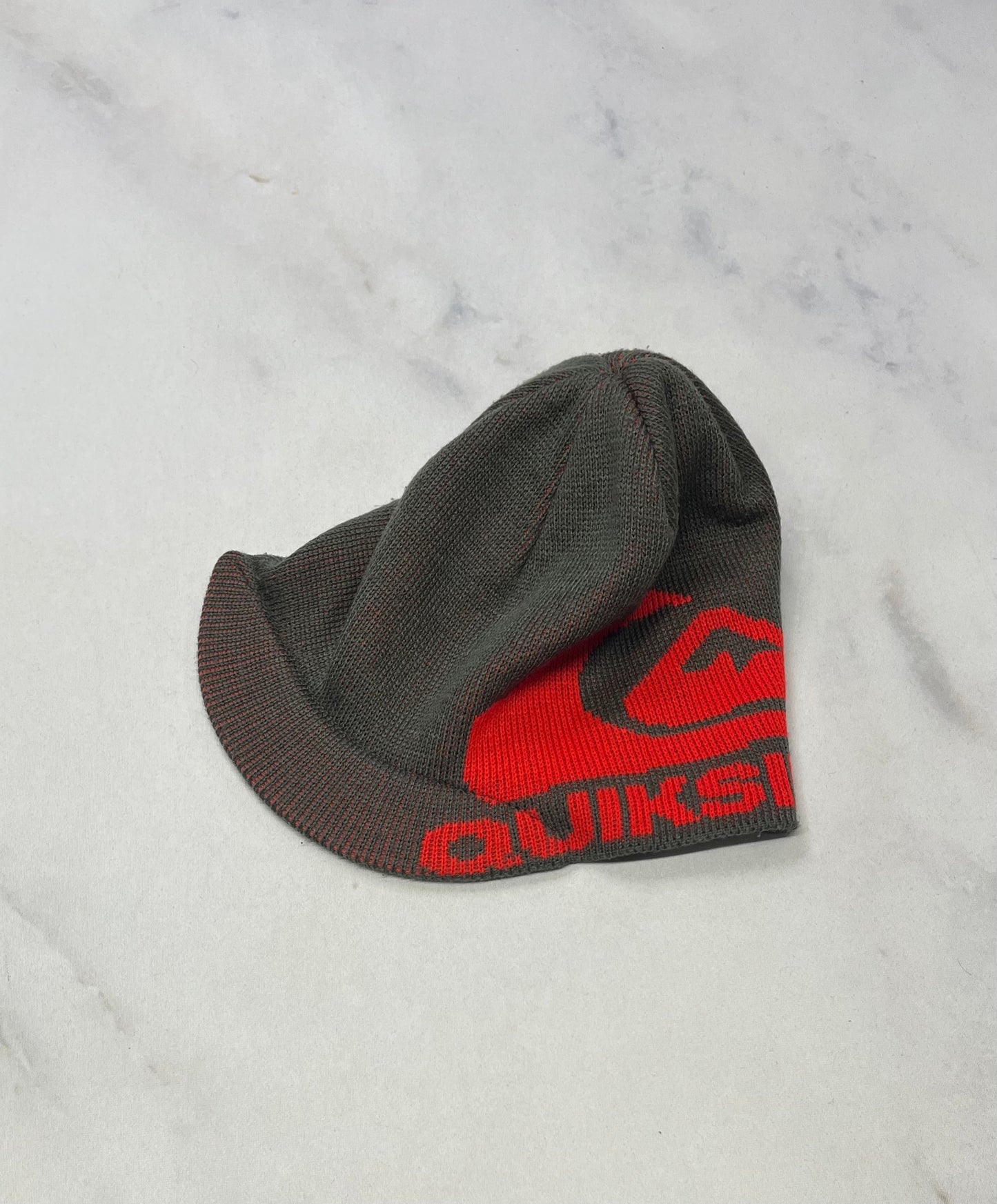 Quiksilver : Tuque charcoal avec bande au devant style casquette . Comme neuve . Fait pour enfant 5-6-7 ans .